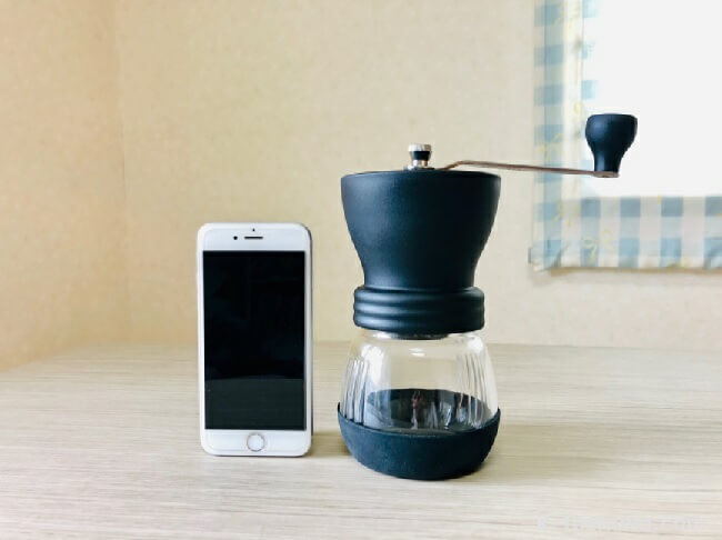 HARIO (ハリオ) 手挽きコーヒーミル セラミック スケルトン ブラック MSCS-2BとiPhone8を並べた画像